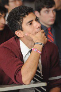 A student listens intently as he wears 2 EndDD wristbands