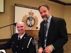 Officer Troy Miller, Sault Ste Marie Police Dept., setting up the technology for the conference, with Joel Feldman