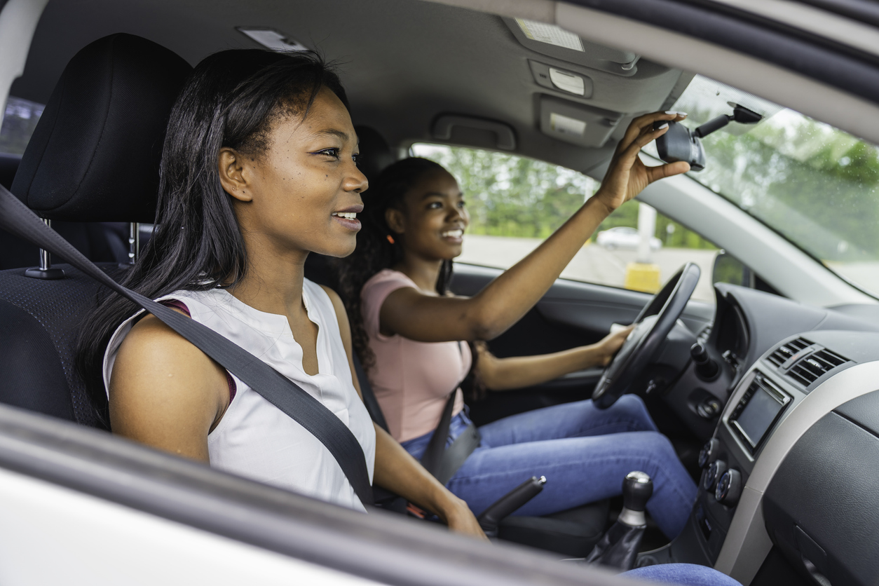 Young teenage driver seated in her new car